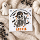 Personalised skeleton Halloween card for boys featuring a hand-drawn skeleton wearing a black checked baseball cap, surrounded by black bats and orange and grey stars. Personalised with a name and relation, suitable for Son, Grandson, Nephew, Godson, Brother or a special little boy.