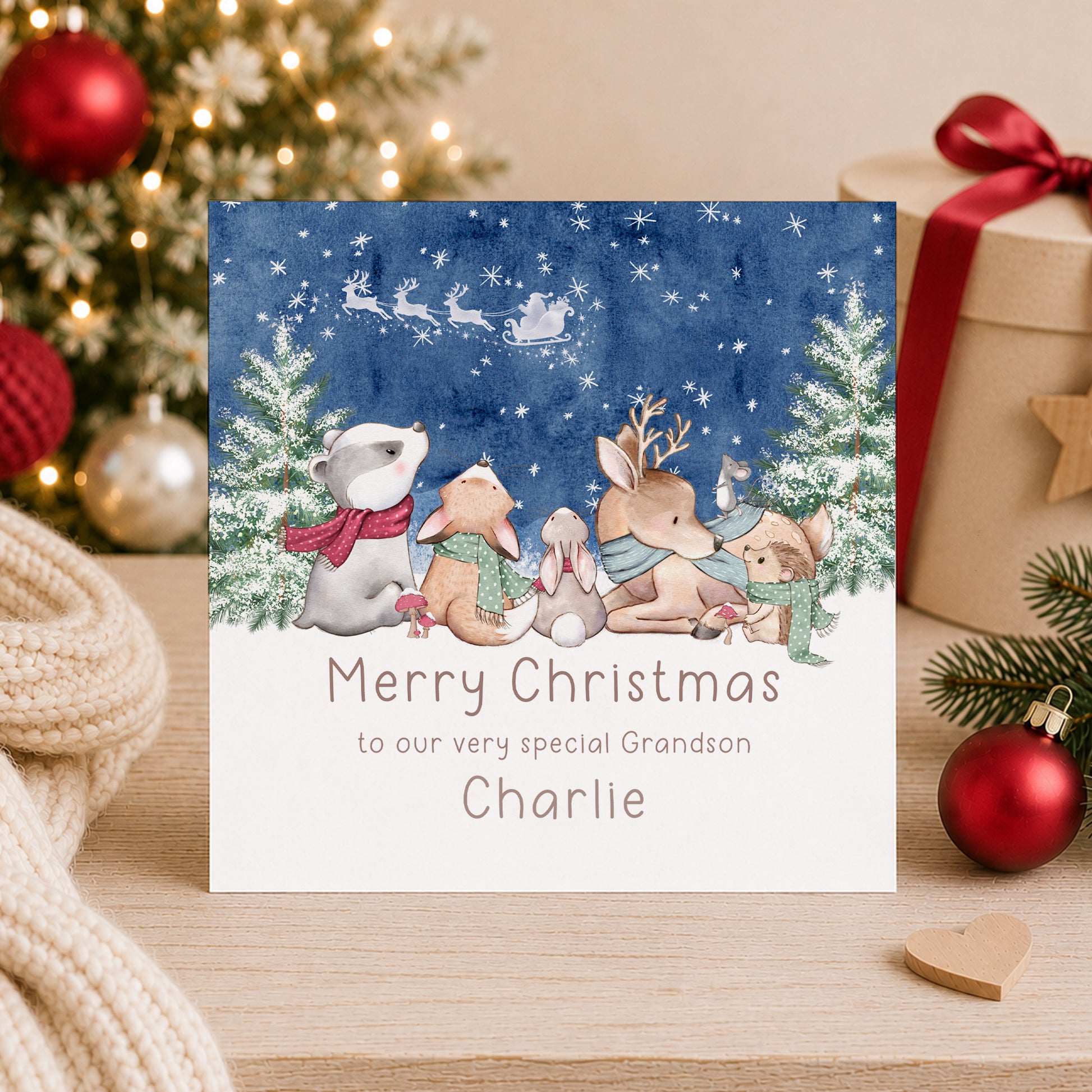 Personalised woodland Christmas card featuring festive winter animals, snowy Christmas trees and Santa’s sleigh, personalised with a name and relation.