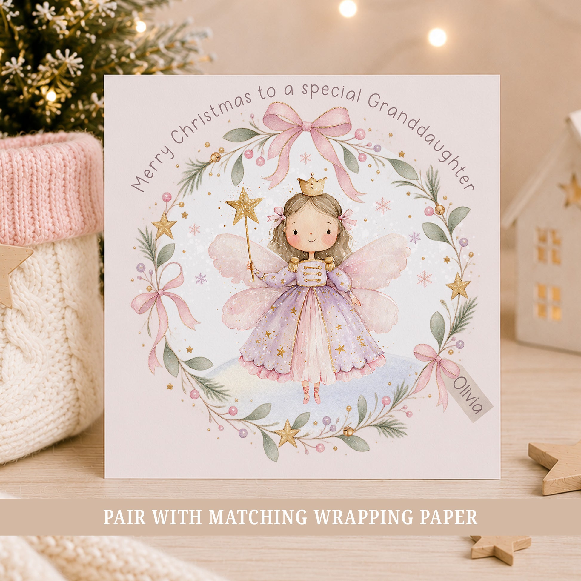 Personalised Granddaughter Christmas card featuring a pink and lilac Nutcracker fairy surrounded by a festive wreath with bows, stars and greenery.