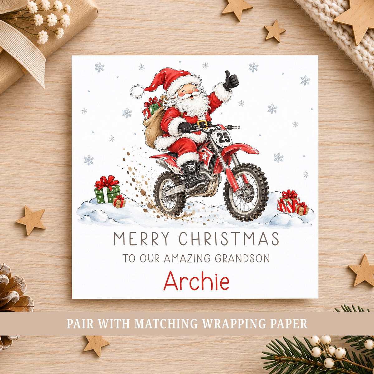 Personalised Christmas card featuring Santa riding a red motocross dirt bike through the snow with Christmas presents and snowflakes, personalised with a name and choice of relation.