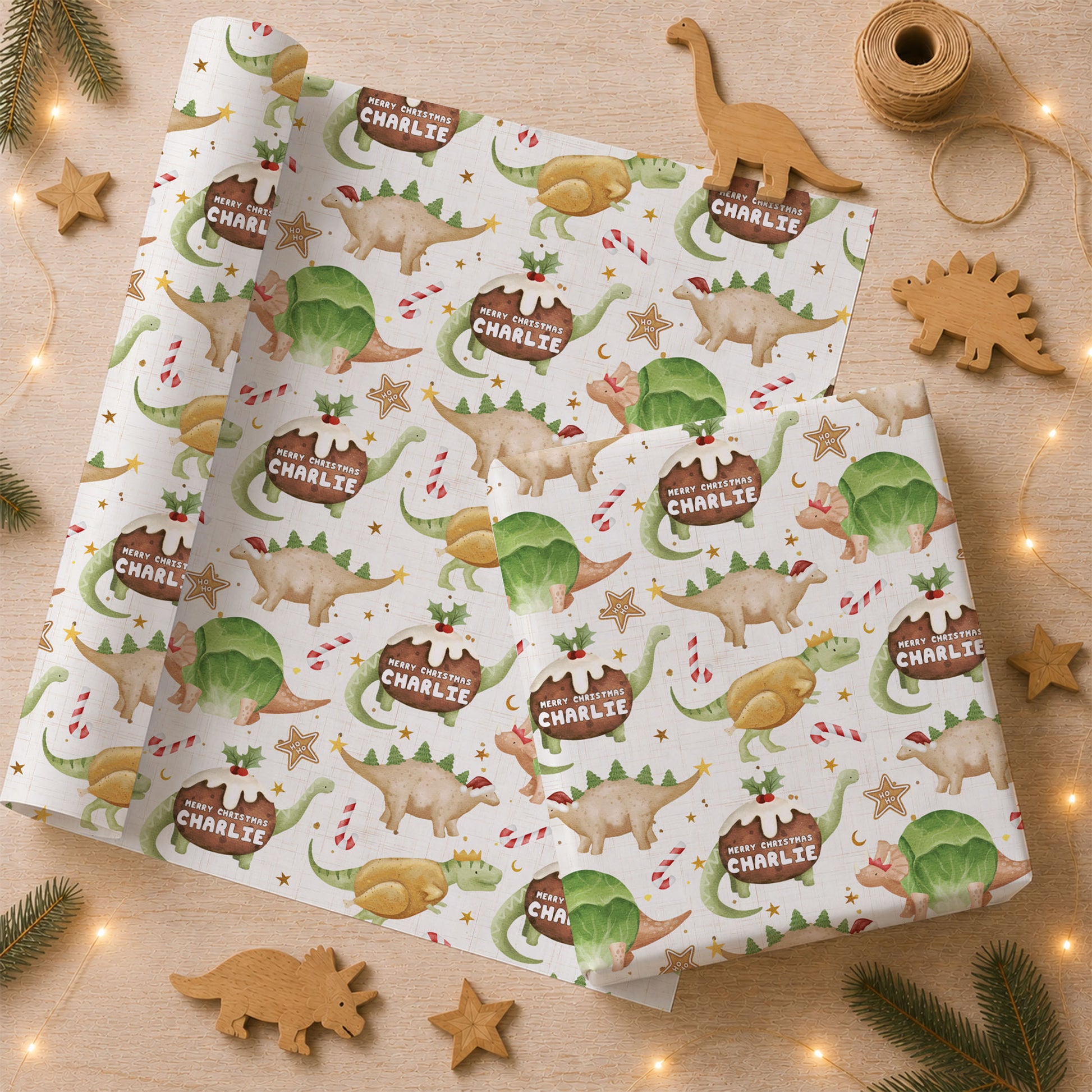 Personalised Christmas wrapping paper with festive dinosaurs, Christmas pudding dinosaurs, candy canes and the child’s name.