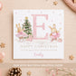 Personalised ballerina bunny Christmas card for girls, featuring two watercolour bunnies wearing pink tutus and ballet shoes beside a decorated Christmas tree with pink baubles, a gold star and wrapped presents. A large pink initial with a snowflake pattern is displayed in the centre, with pink snowflakes and gold details throughout. Personalised with the recipient's name and relation, shown with the letter E for Granddaughter Emily.