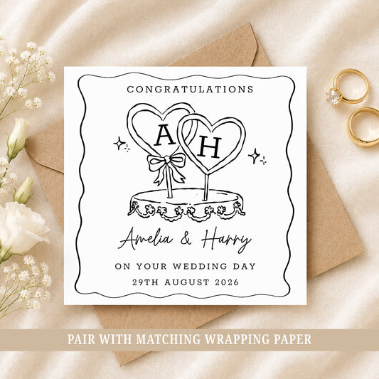 Personalised wedding card featuring a black and white wedding cake with heart toppers, customised with the couple's names and wedding date.