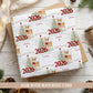 Personalised First Christmas wrapping paper featuring a sweet reindeer with red bow, snowy Christmas tree, red 2026 numbers, stars and snowflakes.