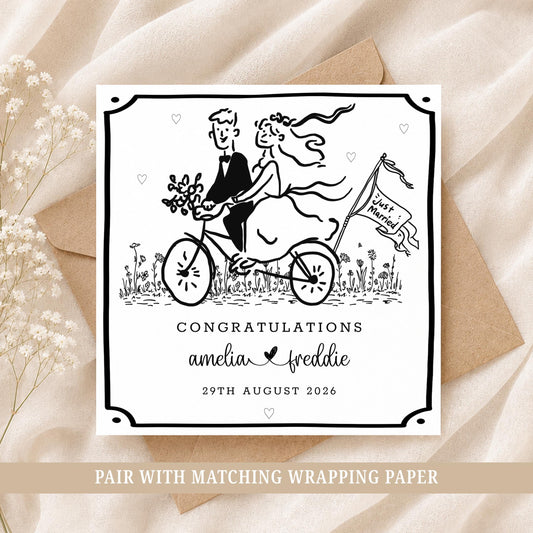 Personalised wedding card featuring a bride and groom riding a bicycle, customised with the couple's names and wedding date.