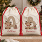 Personalised Christmas sack with a large snowflake patterned initial, cute hand-drawn reindeer, Christmas presents and the child's name printed underneath. Natural poly linen Santa sack with a red drawstring, available in two sizes for boys and girls.