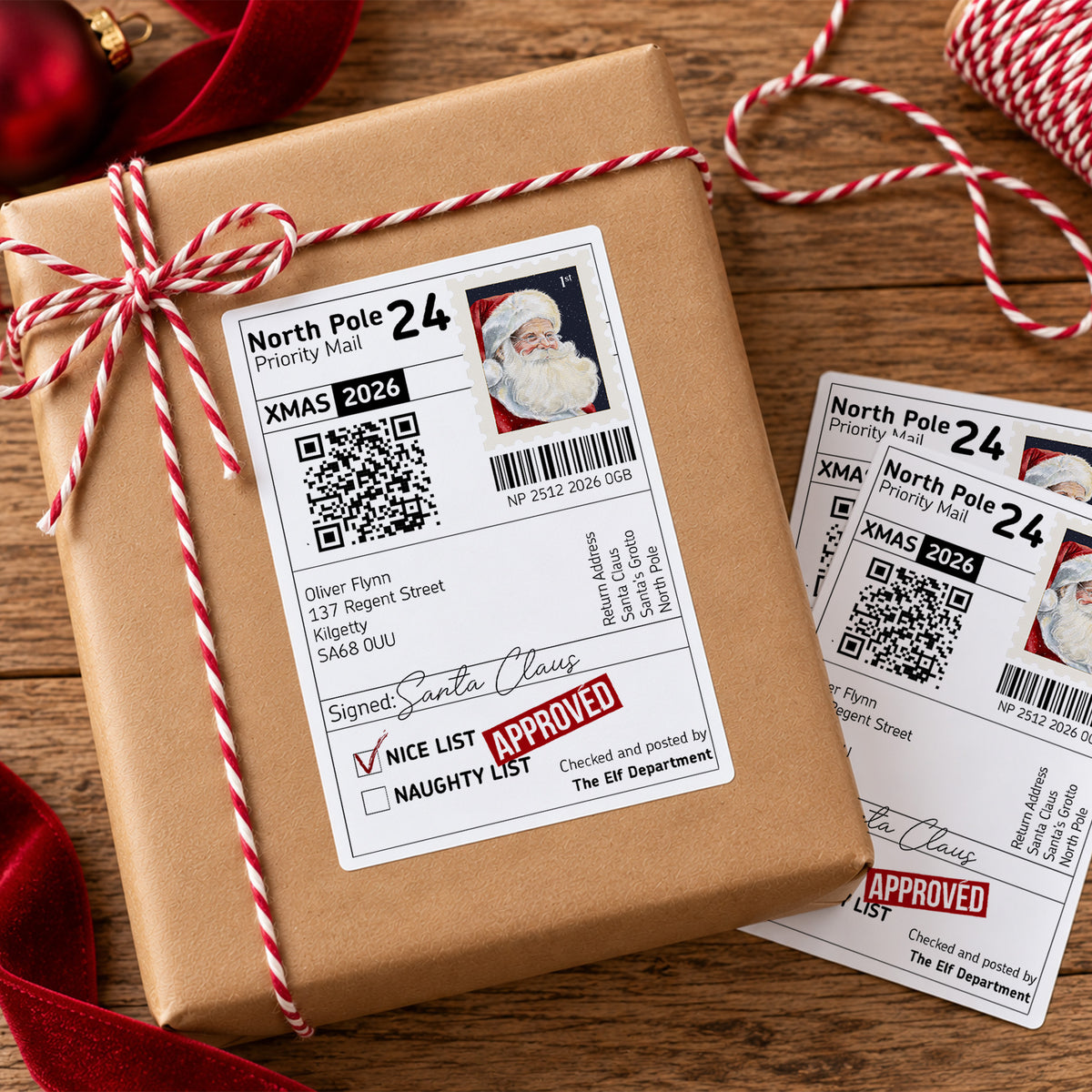 Personalised North Pole Santa delivery sticker measuring 4x6 inches, designed as a Christmas parcel label from Father Christmas. Features a Santa Claus postage stamp, North Pole Priority Mail wording, personalised child's name and address, Nice List Approved stamp, Santa's signature, barcode and interactive QR code to track Santa on Christmas Eve. Large glossy Christmas gift sticker shown on wrapped presents, ideal for creating a special delivery from Santa.