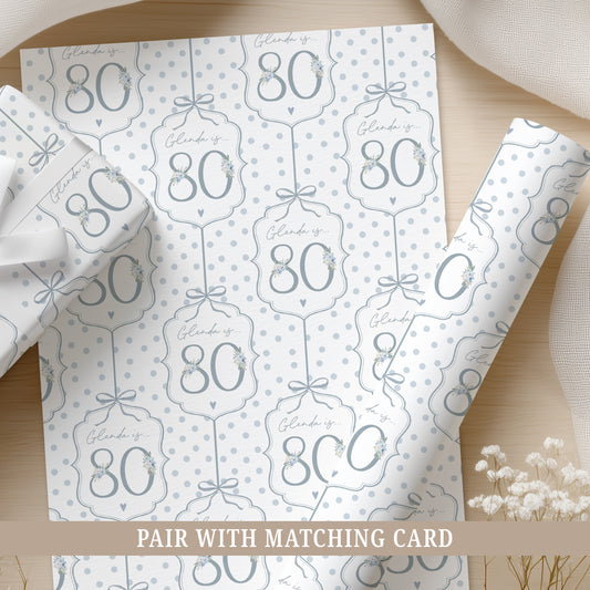 Personalised 80th birthday floral number wrapping paper with blue polka dot background and personalised name.