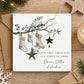 Personalised first Christmas as a family of three card featuring three festive stockings hanging from a eucalyptus branch with star decorations and personalised family names.
