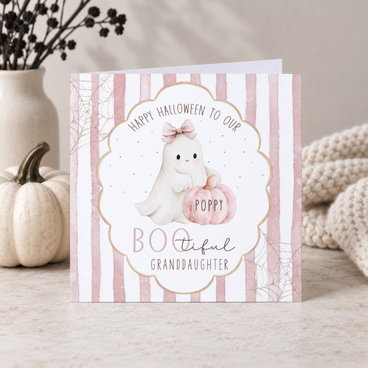 Personalised Granddaughter Halloween card featuring a cute white ghost with a pink bow and personalised pink pumpkin, pink striped background, spider webs and BOOtiful wording. Also available for Daughter, Niece, Goddaughter and other relations.