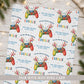 Personalised gamer Christmas wrapping paper featuring colourful festive game controllers, Christmas lights, stars and the recipient’s name.
