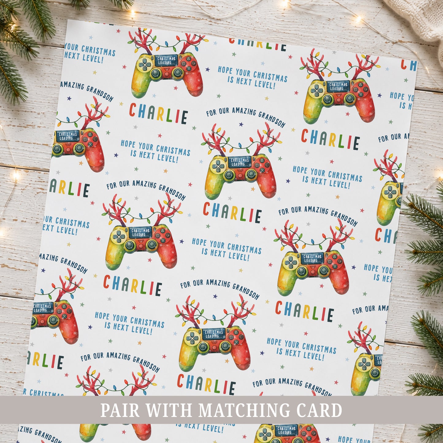 Personalised gamer Christmas wrapping paper featuring colourful festive game controllers, Christmas lights, stars and the recipient’s name.