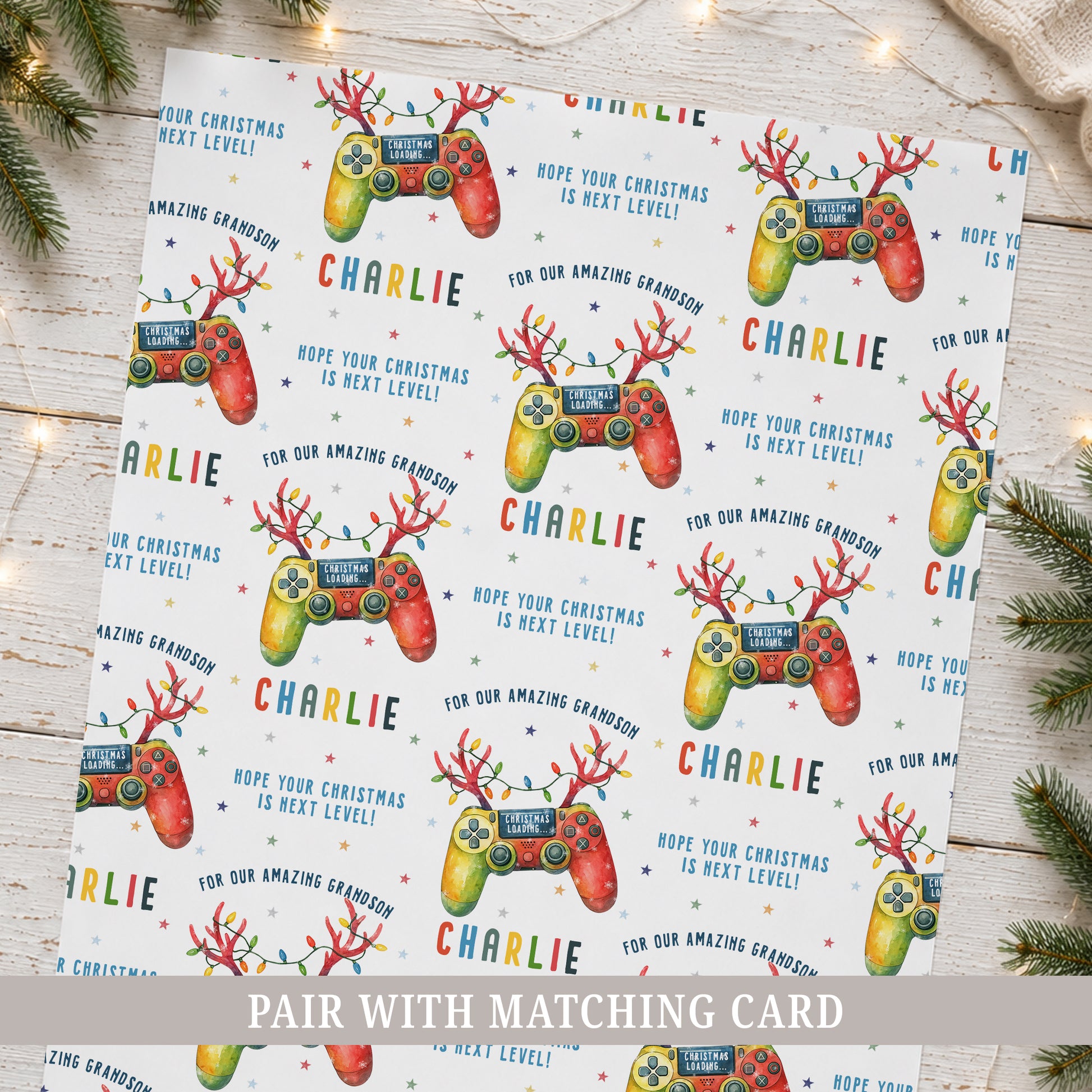 Personalised gamer Christmas wrapping paper featuring colourful festive game controllers, Christmas lights, stars and the recipient’s name.