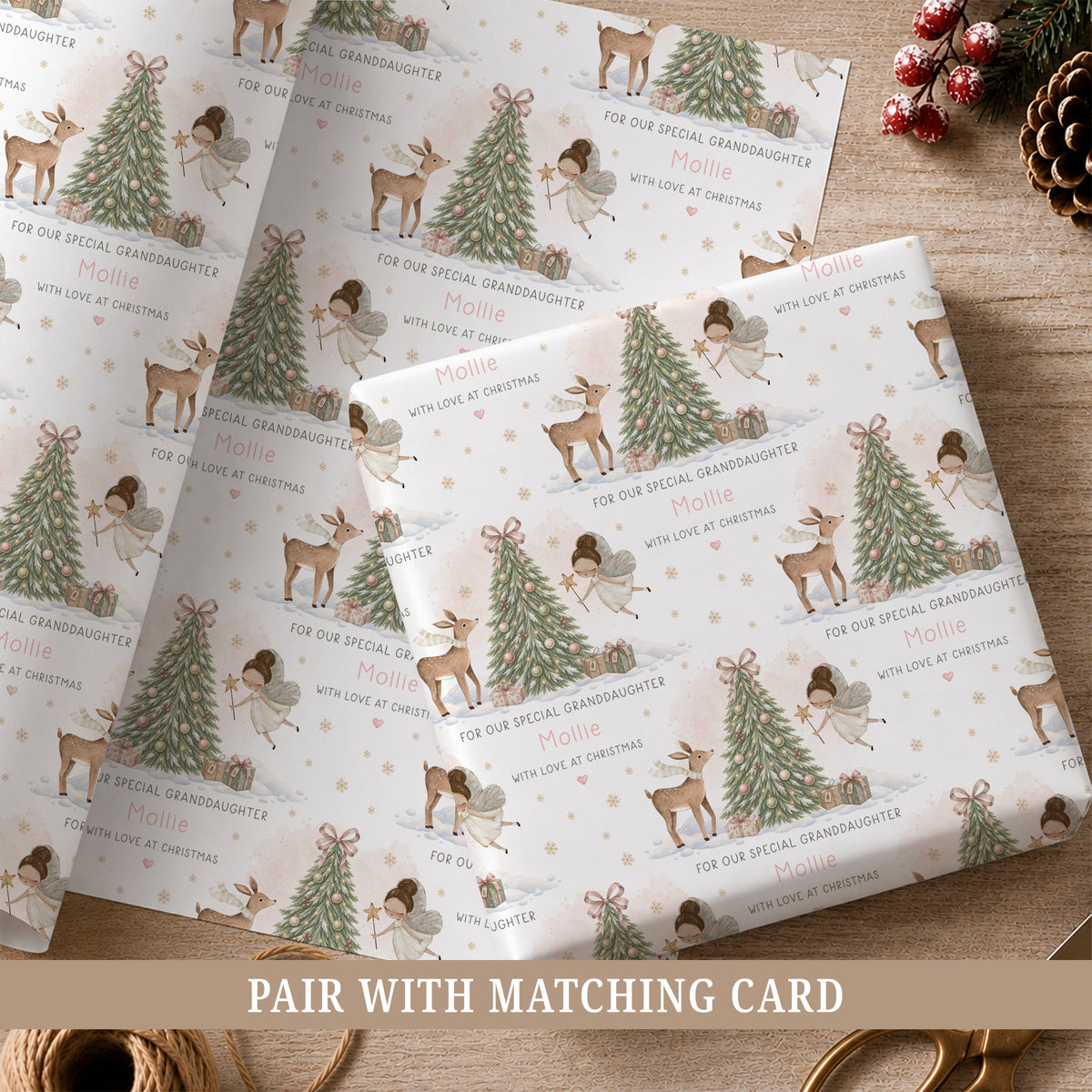 Personalised fairy Christmas wrapping paper for girls featuring a hand-painted fairy, deer, decorated Christmas tree, presents, snowflakes and soft snowy woodland details, personalised with a name and relation for Daughter, Granddaughter, Niece, Goddaughter or another special girl.