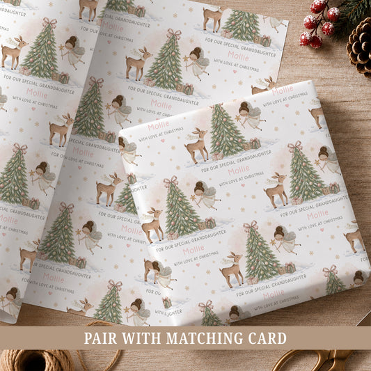 Personalised fairy Christmas wrapping paper for girls featuring a hand-painted fairy, deer, decorated Christmas tree, presents, snowflakes and soft snowy woodland details, personalised with a name and relation for Daughter, Granddaughter, Niece, Goddaughter or another special girl.