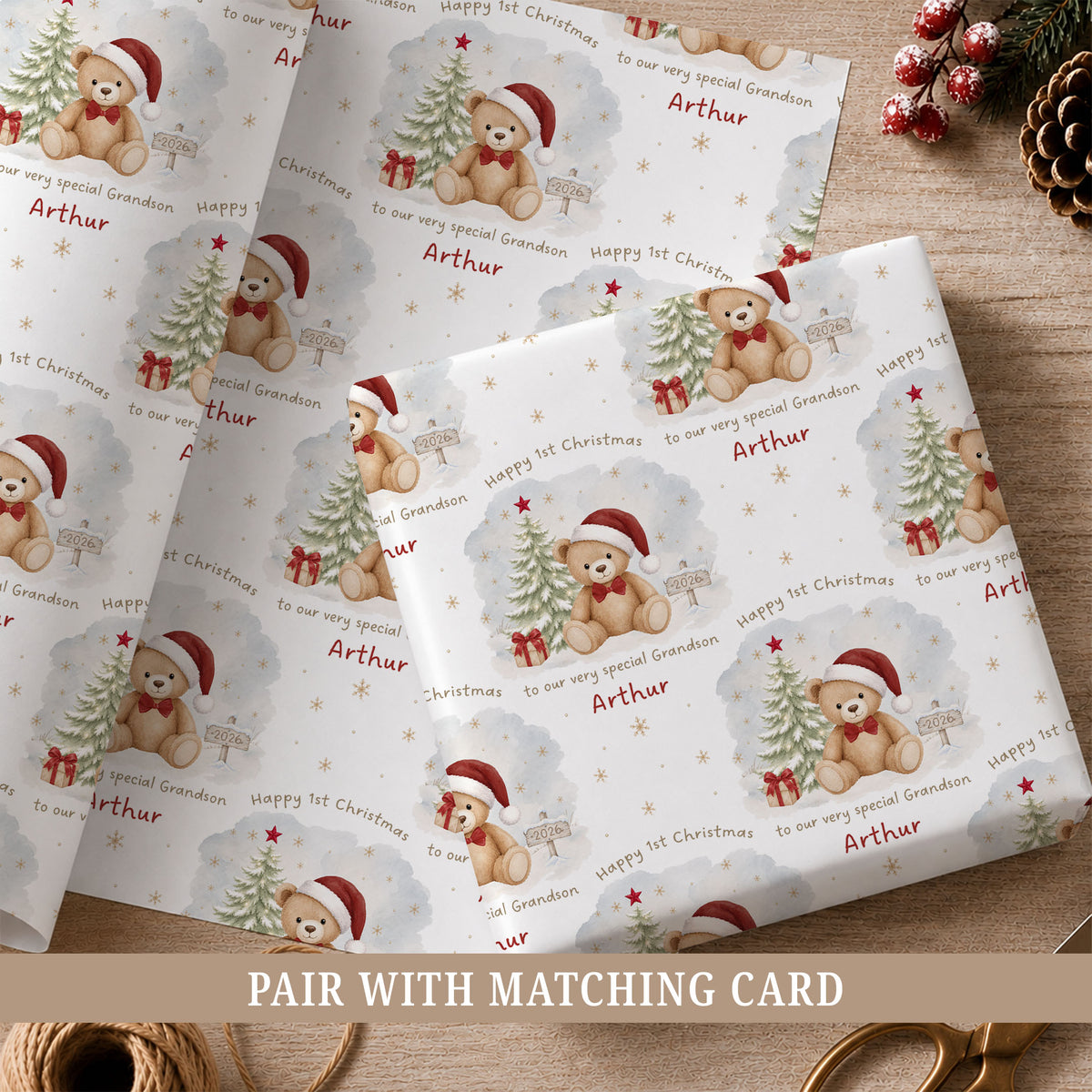Personalised Grandson's First Christmas wrapping paper featuring a cute teddy bear wearing a red Santa hat beside a snowy Christmas tree, festive presents and snowflakes. This baby boy's 1st Christmas gift wrap can be customised with a name and relation, including Grandson, Nephew, Son or Godson.