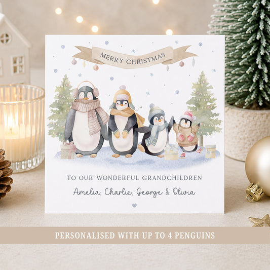 Personalised grandchildren Christmas card featuring up to four cute watercolour penguins in a festive snowy scene with Christmas trees and presents, personalised with each grandchild’s name.