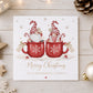 Personalised couple Christmas card featuring two Christmas gnomes in red snowflake mugs with candy canes and individual name tags, customised with two names and your chosen relation wording for couples including Daughter and Boyfriend, Son and Girlfriend, Brother and Sister-in-Law, same-sex couples and more.