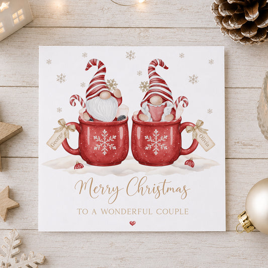 Personalised couple Christmas card featuring two Christmas gnomes in red snowflake mugs with candy canes and individual name tags, customised with two names and your chosen relation wording for couples including Daughter and Boyfriend, Son and Girlfriend, Brother and Sister-in-Law, same-sex couples and more.